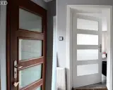 Przed i po: brązowe drzwi z przeszkleniami po lakierowaniu na biało. Odświeżony wygląd wnętrza.
